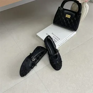 Detailed top-down view of black embroidered mesh flat shoes with elegant floral patterns