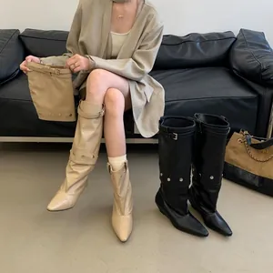 Detail view of women's pointed-toe leather gaiter boots with buckle straps and wedge heels