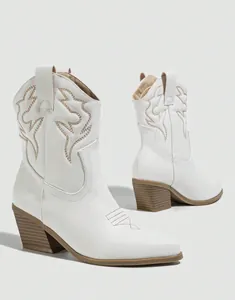 Close-up view of white western cowboy boots with elegant decorative embroidery stitching
