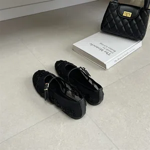 Detail view of black mesh flats with exquisite floral embroidery and Mary Jane strap.