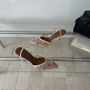 Detalle de elegantes zapatos de tacón con bordado de flores y malla retro