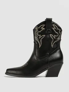 Side detail of a black faux leather cowboy boot featuring vintage white stitching