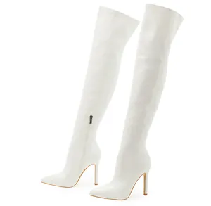 Detail view of white patent leather over-the-knee boots with pointed toe and stiletto heel.