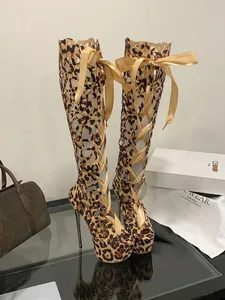 Detailed macro view of leopard print lace-up high-heeled boots with platform and peep-toe design