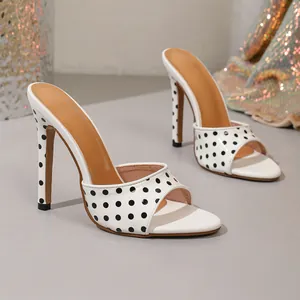 Detailed side view of elegant white polka dot high heel sandals featuring an open toe design