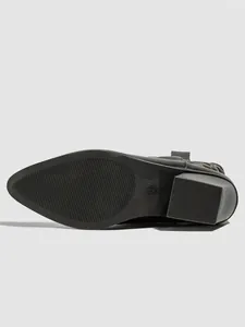 Detailed view of the non-slip rubber sole and heel of a black pointed-toe boot