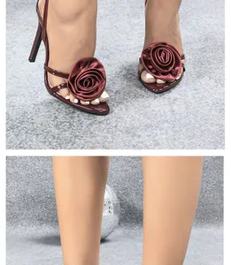 Close-up detail of burgundy high-heel sandals with elegant fabric flower decoration