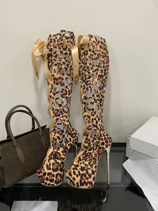 Chic leopard print knee-high gladiator heels featuring lace-up design and platform