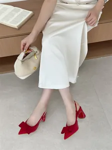 Detailed view of elegant red pointed-toe slingback high heels featuring a chic decorative bow.