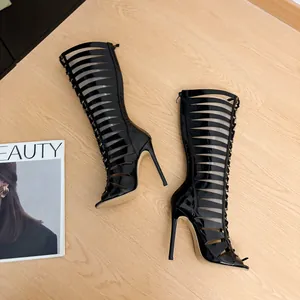 Top down detailed view of black patent hollow-out stiletto heel Roman style boots.