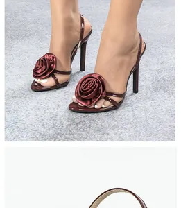 Close-up of elegant burgundy high-heeled sandals with large satin rose detail
