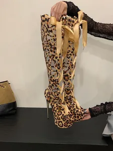 Detailed view of leopard print lace-up thigh high boots with peep toe and platform heels
