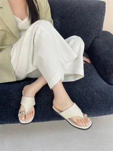 Stijlvolle crème platte sandalen voor dames met een chique zilveren metalen teenring.