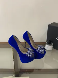 Blaue Samt-High-Heels mit funkelnden Strass-Schleifen und hohen Stiletto-Absätzen.