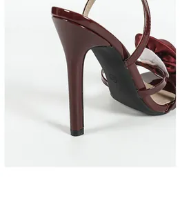 Close-up view of the elegant burgundy patent leather stiletto heel and floral detail
