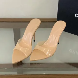 Close-up of nude pointed-toe high heel mules with transparent strap.