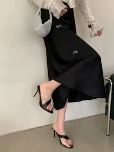 Detailansicht schwarzer Stiletto-Sandaletten mit transparentem Riemen und Steinmuster