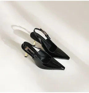 Gros plan sur d'élégants talons slingback en cuir verni noir avec talons aiguilles dorés