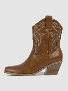 Close-up detail of a brown Western cowboy ankle boot with white embroidery pattern