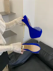 Side and sole detail of electric blue velvet platform heels with rhinestone bow