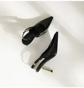 Vue détaillée de talons hauts en cuir verni noir avec un talon aiguille doré chic