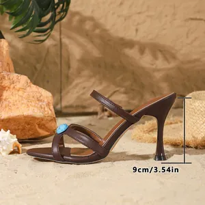 Vue latérale montrant le talon aiguille de 9 cm d'une sandale brune ornée de gemmes