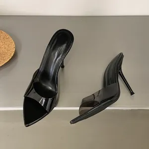 Detailed view of elegant black pointed-toe stiletto mules with clear transparent straps.
