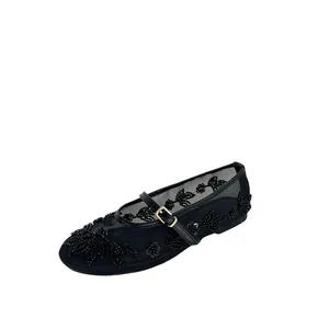 Close-up of black mesh flat shoe with intricate floral bead embroidery and strap.