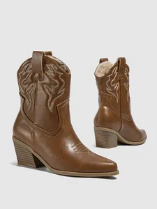 Detailed side view of brown western cowboy ankle boots with white embroidery and chunky heel