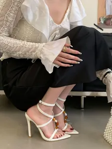Elegante witte sandalen met spitse neus en hoge hakken met barnsteen kralen, 9 cm hak.