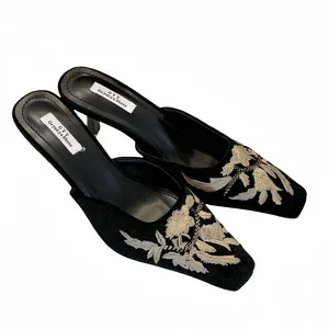 Elegantes mules negros de punta con bordado floral blanco y tacones de aguja