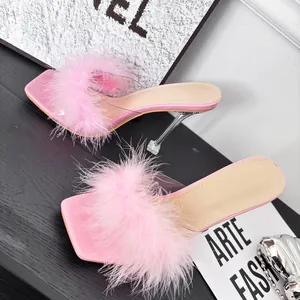 Detail of pink faux fur high heel sandals with transparent straps and clear heels