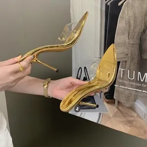 Close-up of elegant gold pointed toe sandals with transparent strap and stiletto heel