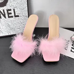 Close-up detail of the pink faux fur straps and transparent block heels on these stylish mules
