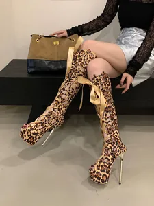 Close-up detail of leopard print lace-up thigh-high platform stiletto boots worn by a model