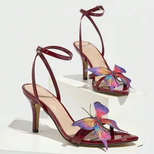 Elegant wine red patent leather sandals featuring a vivid colorful butterfly ornament.