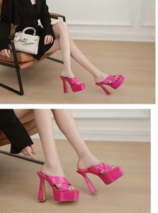 Detalle de mules fucsia de tacón alto y plataforma con acabado brillante y tiras cruzadas