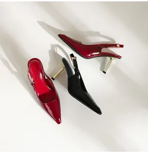 Détail d'élégants escarpins slingback en cuir verni avec de fins talons aiguilles dorés.