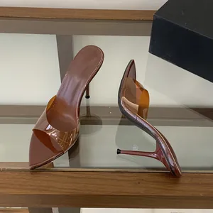 Close-up of brown stiletto mule sandals with transparent PVC strap and pointed toe.