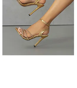 Elegant close-up of gold metallic stiletto sandals featuring sparkling rhinestone straps