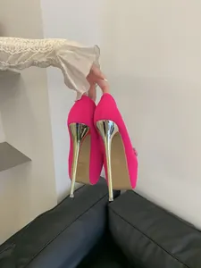 Fuchsia platform pumps with gold stiletto heels and rhinestone bow detail.