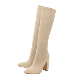 Detailweergave van beige gebreide stretchlaarzen met dikke hakken en puntige neuzen.