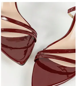 Close-up detail of glossy red patent leather high heel sandals with strappy pointed toe