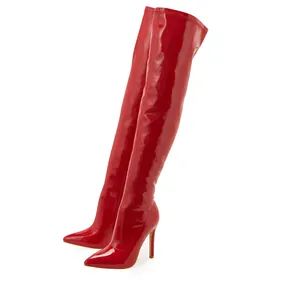 Detail view of vibrant red patent leather over-the-knee boots with pointed toe and stiletto heels.