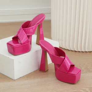 Mules fucsia vibrantes con plataforma, tacón alto de bloque y tiras cruzadas de charol.