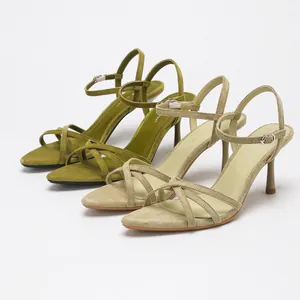 Elegant suede high-heeled sandals with crossed straps in green and beige colors.