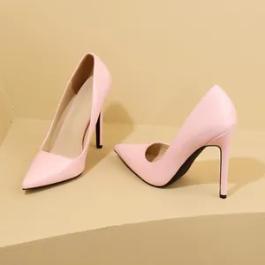 Close-up of elegant pink patent leather stiletto pumps with pointed toe on beige stairs.