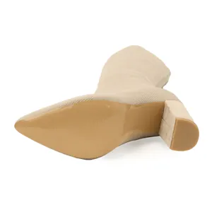 Detailweergave van de zool en de blokhak van een beige gebreide elastische stretchlaars