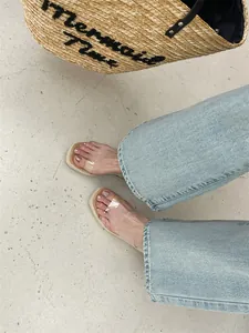 Detailed view of fashionable women's square toe wedge slippers with clear PVC straps