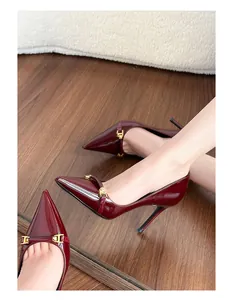 Macro view of elegant wine red patent leather stiletto heels with gold buckle detail